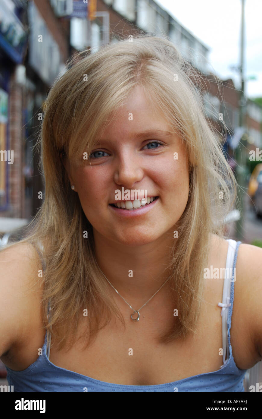 Giovane ragazza bionda sorridente alla fotocamera, Oxford, Oxfordshire, England, Regno Unito Foto Stock