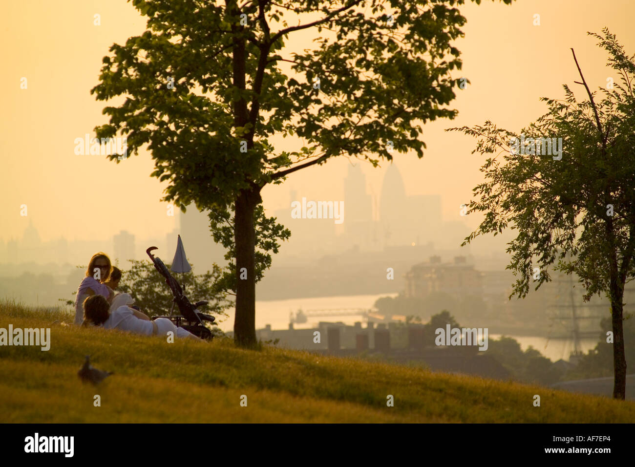 La città di Londra dal parco di Greenwich con le persone che si rilassano in primo piano Foto Stock