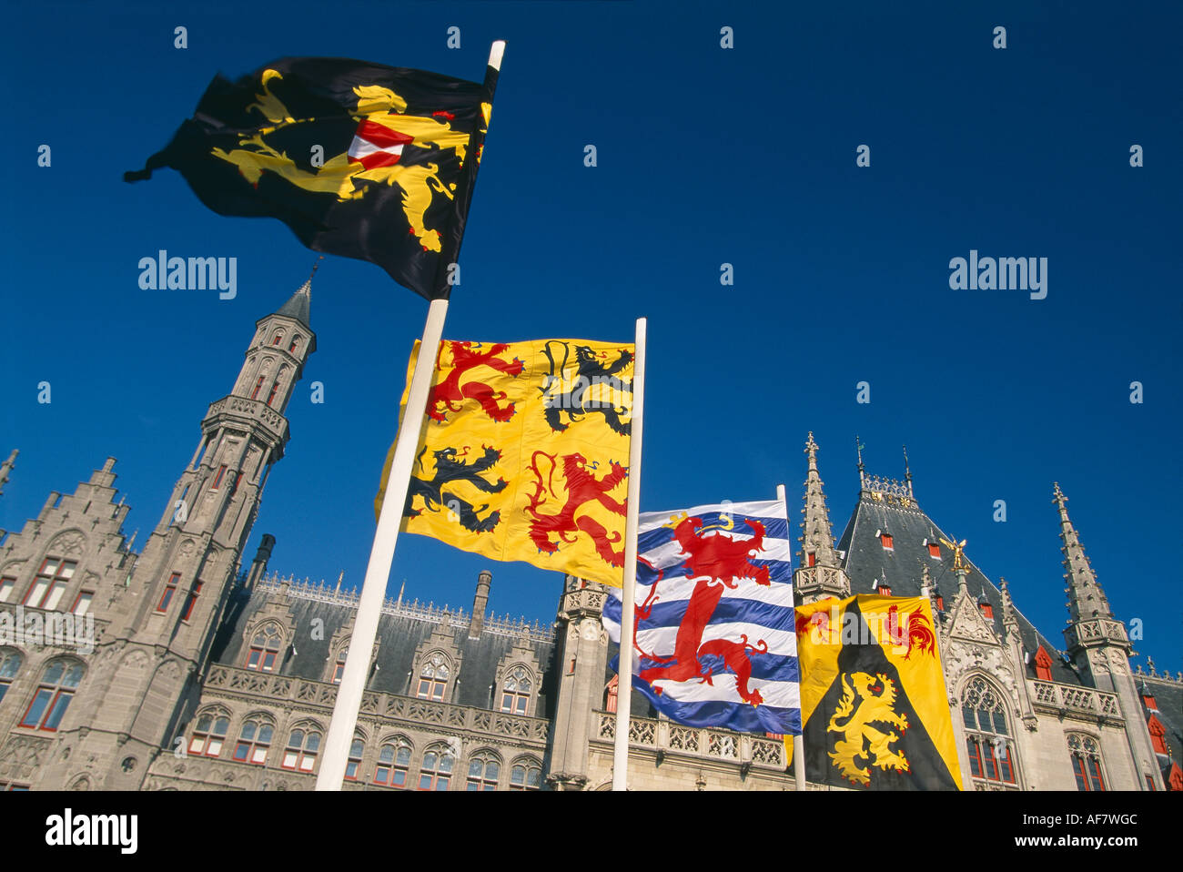 Bandiere in Markt con torri guglie Brugge Belgio Foto Stock