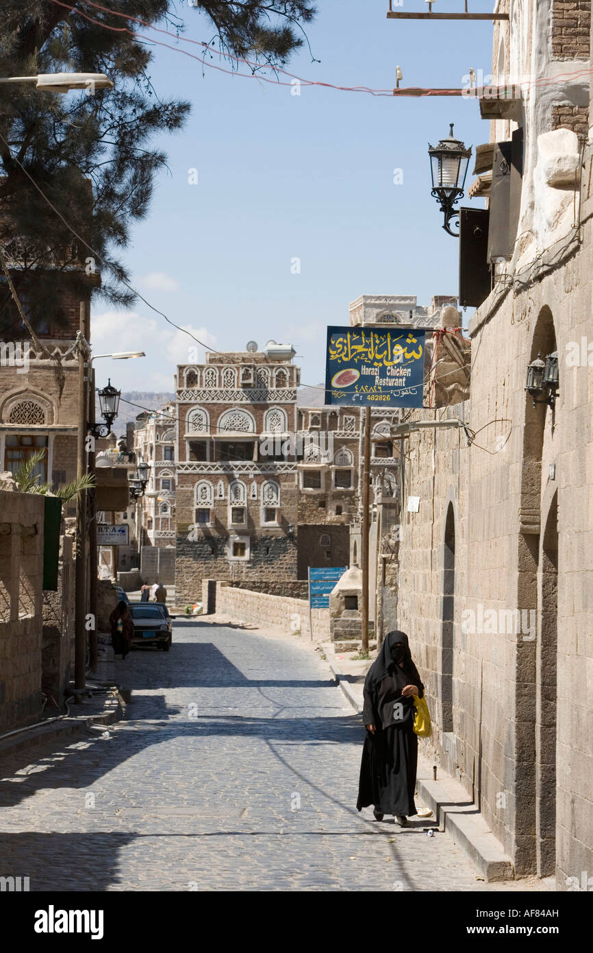 Donna su una strada a Sana'a old town, Sana'a, Yemen Foto Stock
