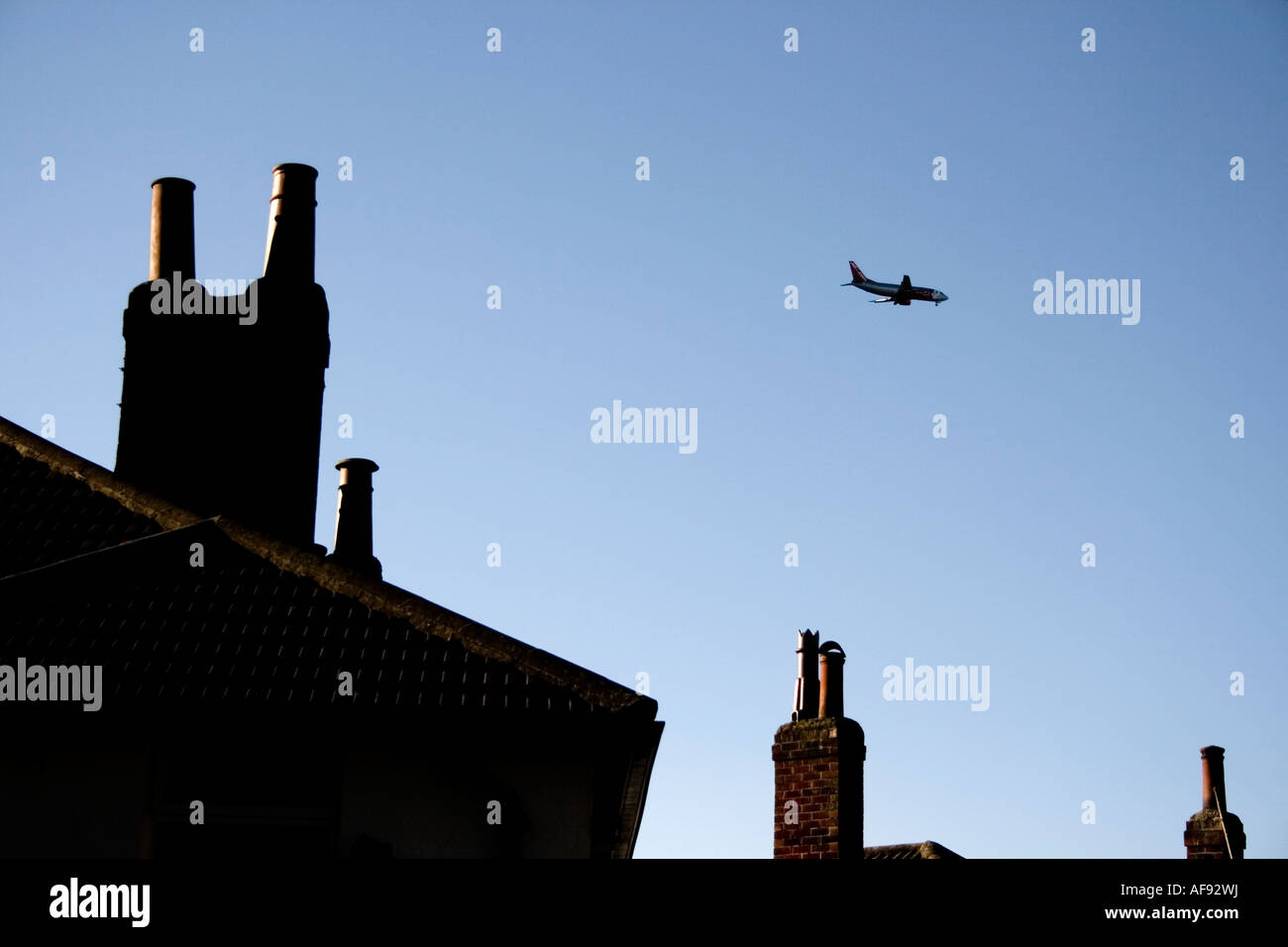 Bassa volare aerei di atterraggio su case Foto Stock
