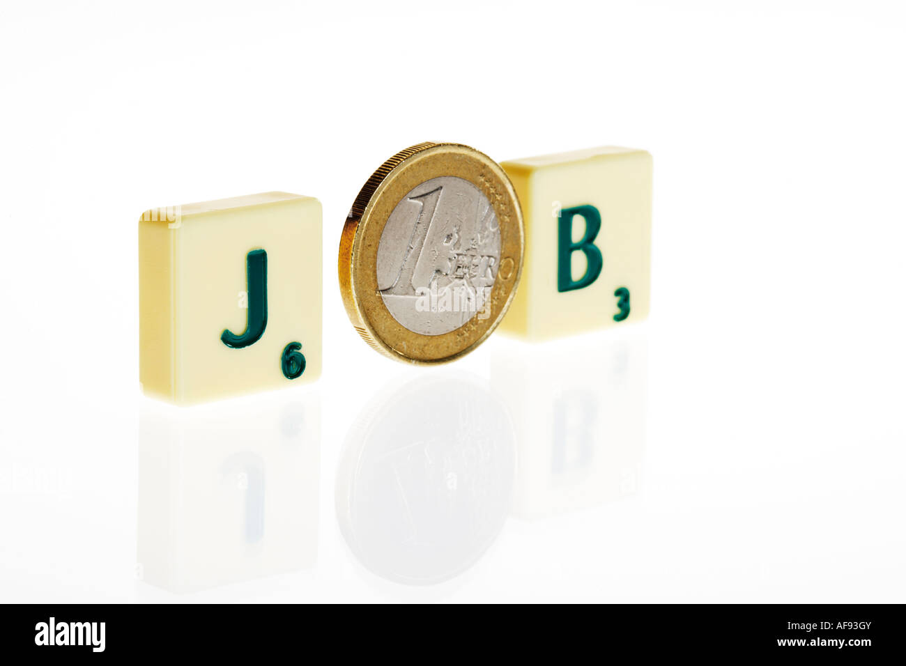 Monete in euro tra piastrelle scrabble Foto Stock