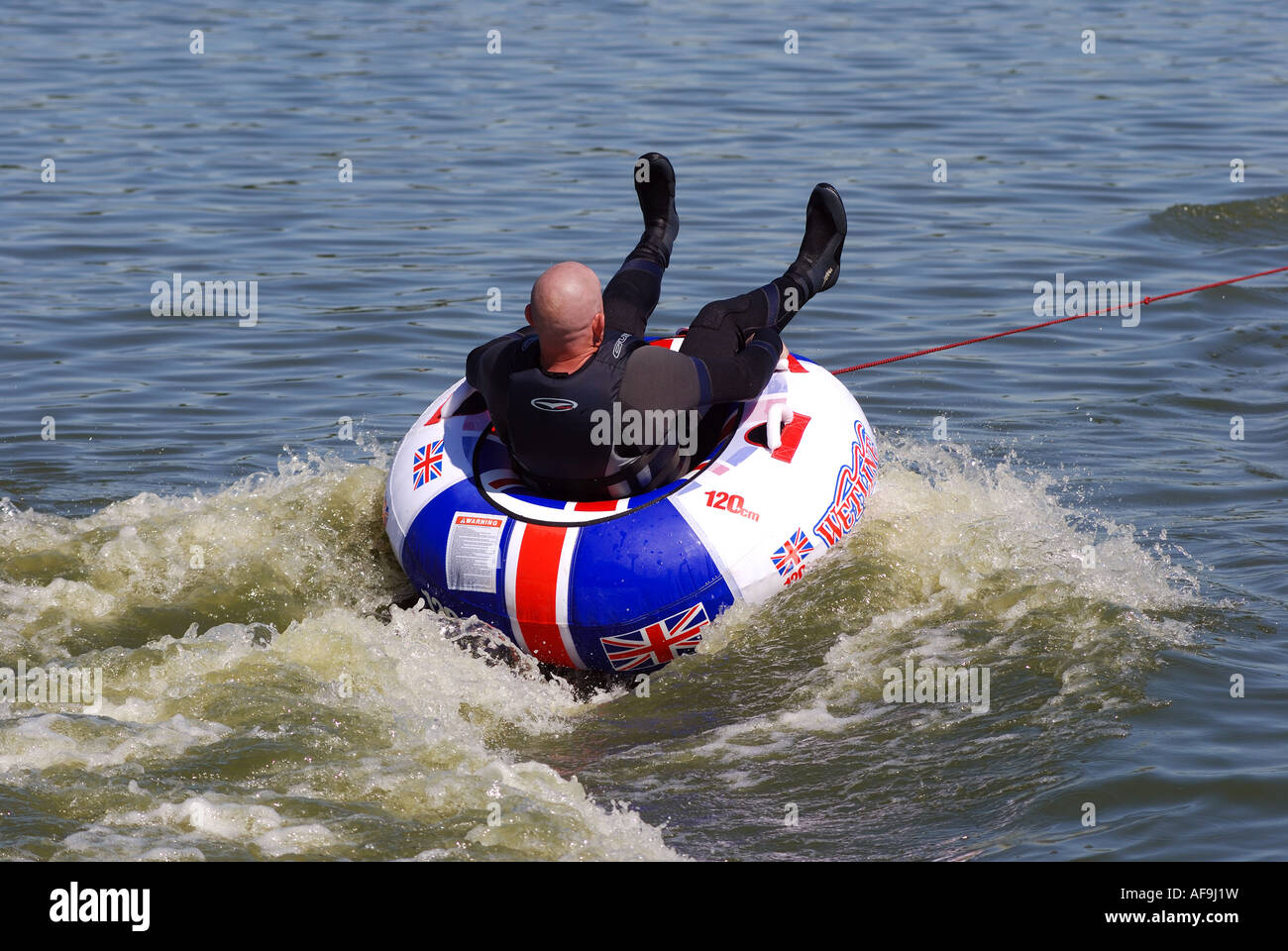 L'uomo sul gommone trainato da jet ski a Kingsbury Water Park, Warwickshire, Inghilterra, Regno Unito Foto Stock