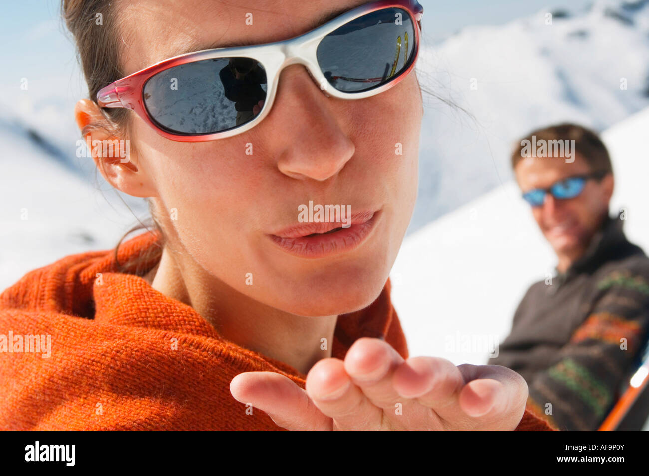 Matura in montagna, donna bacio di soffiatura Foto Stock