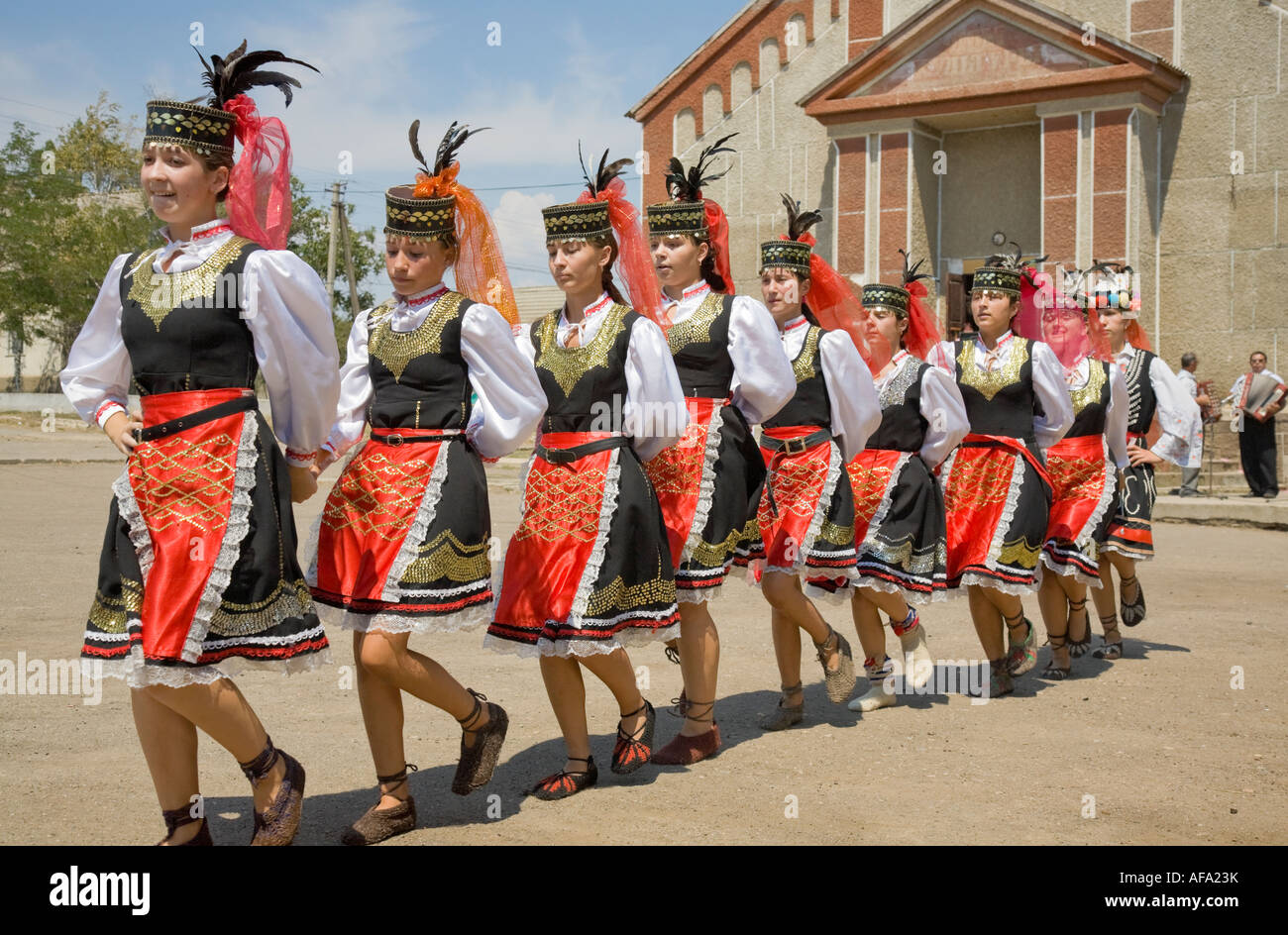 Le giovani ragazze nei tradizionali costumi ucraino dancing di fronte alla casa di città in Plotzk / Ucraina Foto Stock
