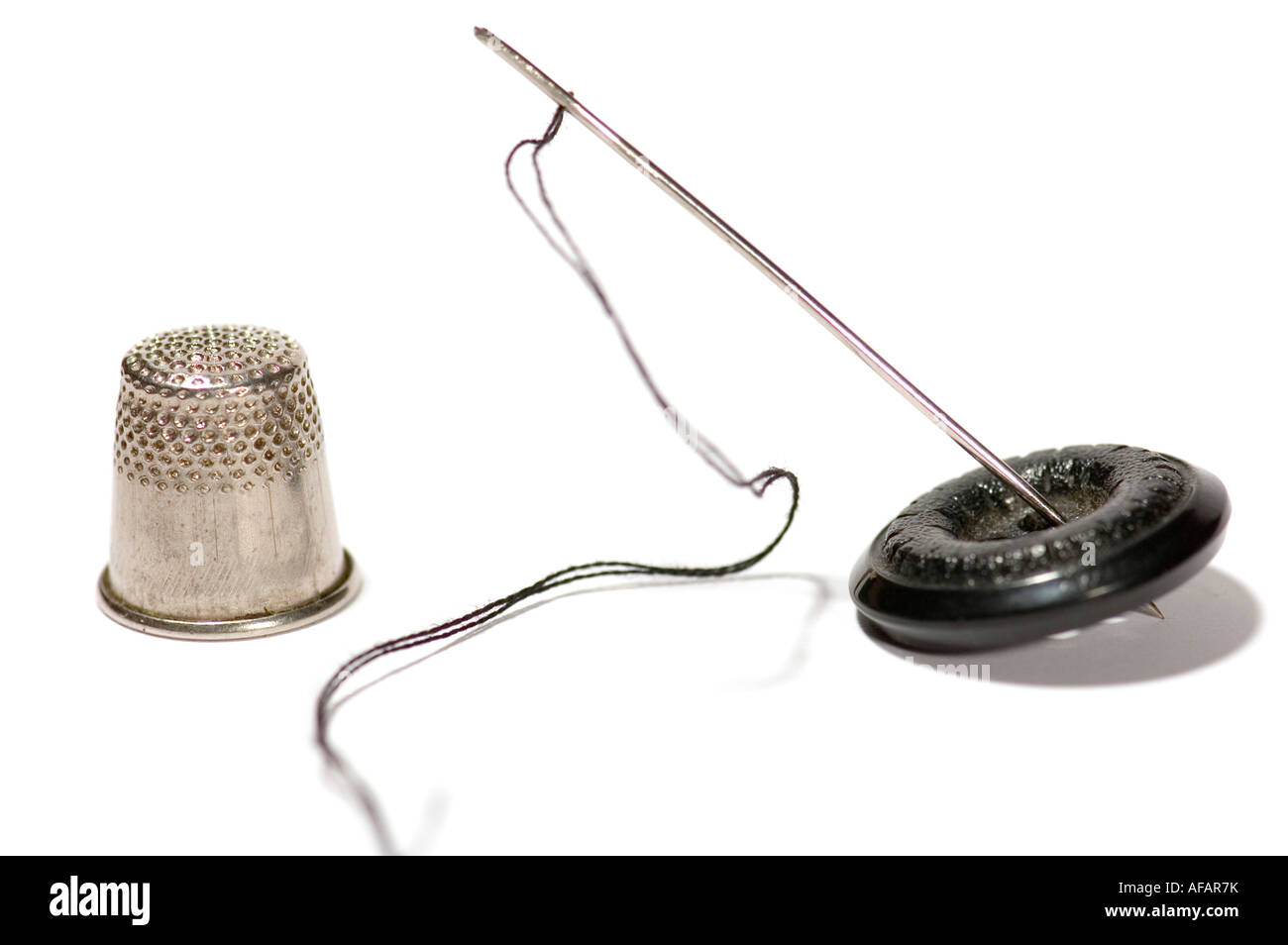 Oggetto di serie su bianco ditale con ago di cucitura Foto Stock
