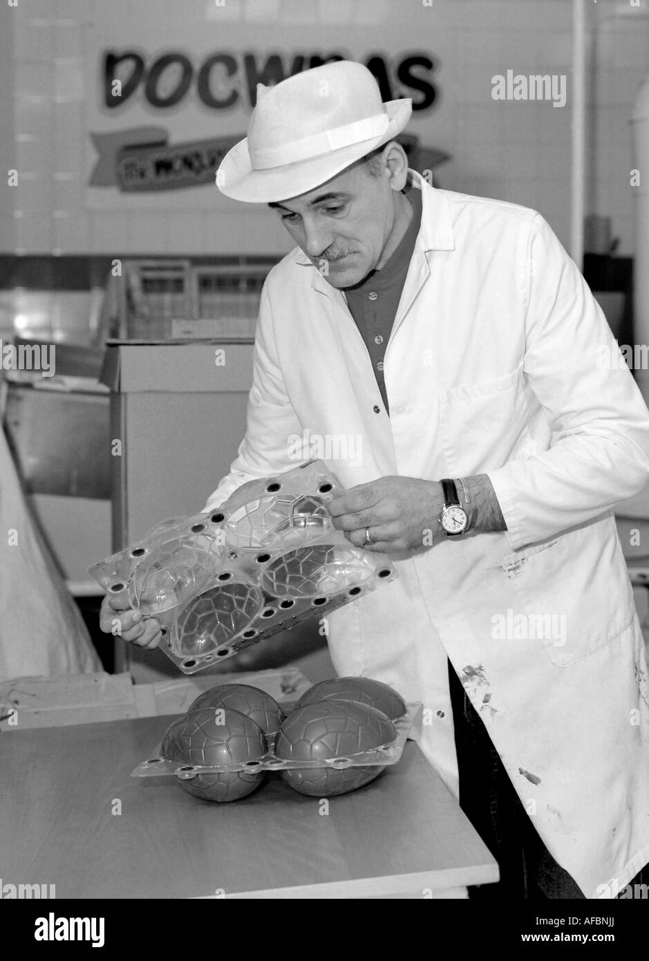 Creatore di cioccolato apre uovo di cioccolato stampo, rivelando finito di uova pasquali a Great Yarmouth fabbrica di cioccolato. Foto Stock