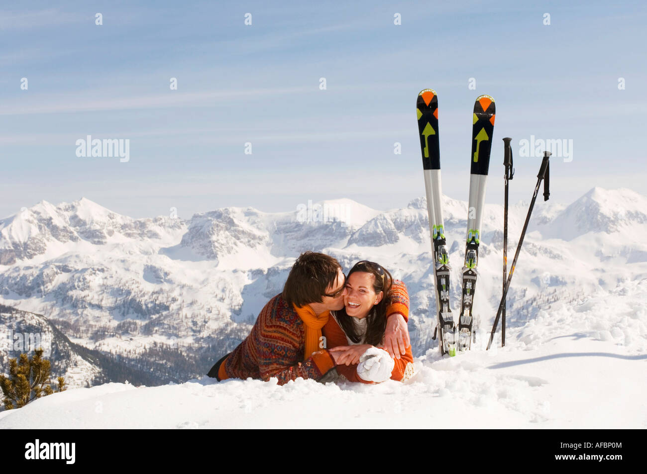 Coppia giacendo in neve, flirtare Foto Stock