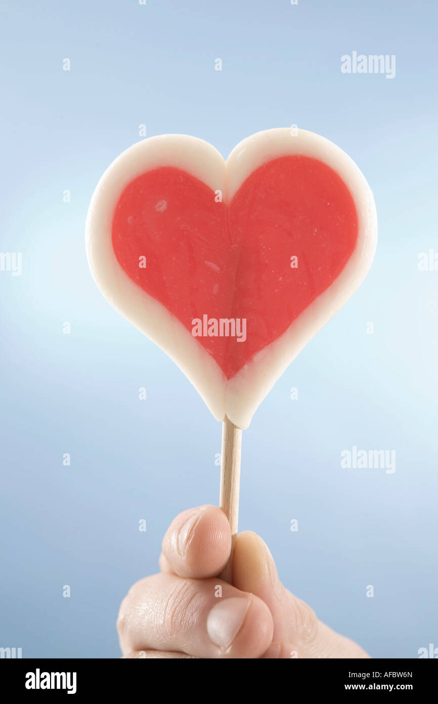 Hoding a mano a forma di cuore lecca-lecca, close-up Foto Stock