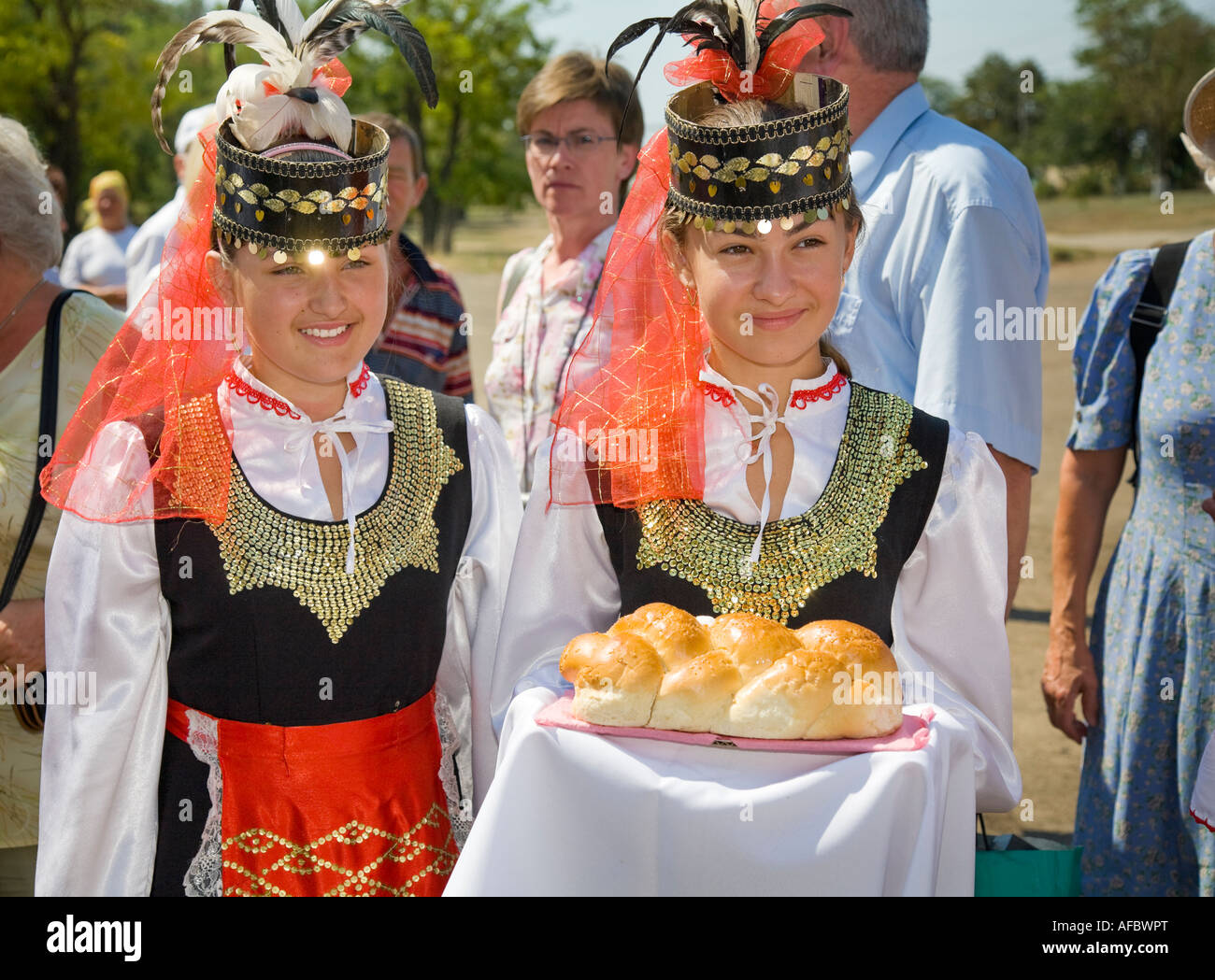 Le giovani ragazze nel tradizionale costume ucraino, trasporto a un gruppo di visitatori la tradizionale accoglienza presente, pane e sale Foto Stock