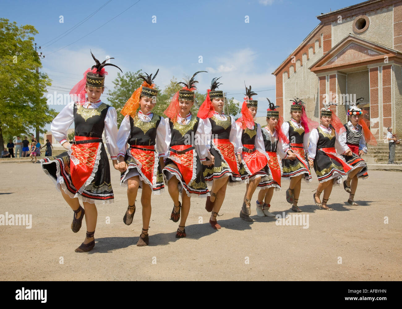 Le giovani ragazze nei tradizionali costumi ucraino dancing di fronte alla casa di città in Plotzk / Ucraina Foto Stock