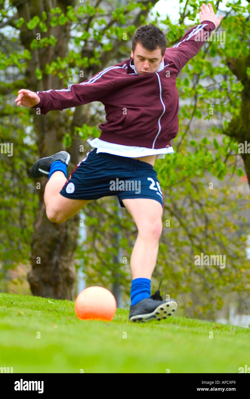 Giovane uomo giocando a calcio calcio Foto Stock