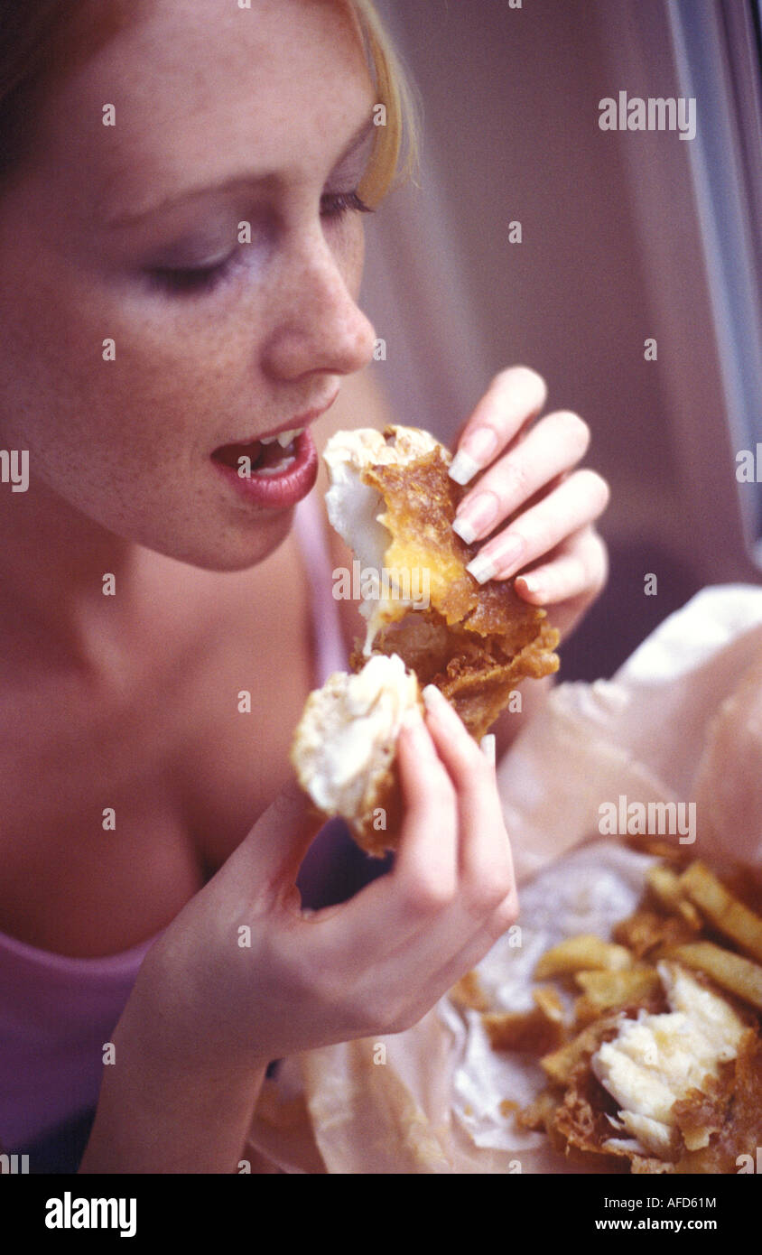 Donna di mangiare pesce e patatine fritte Foto Stock