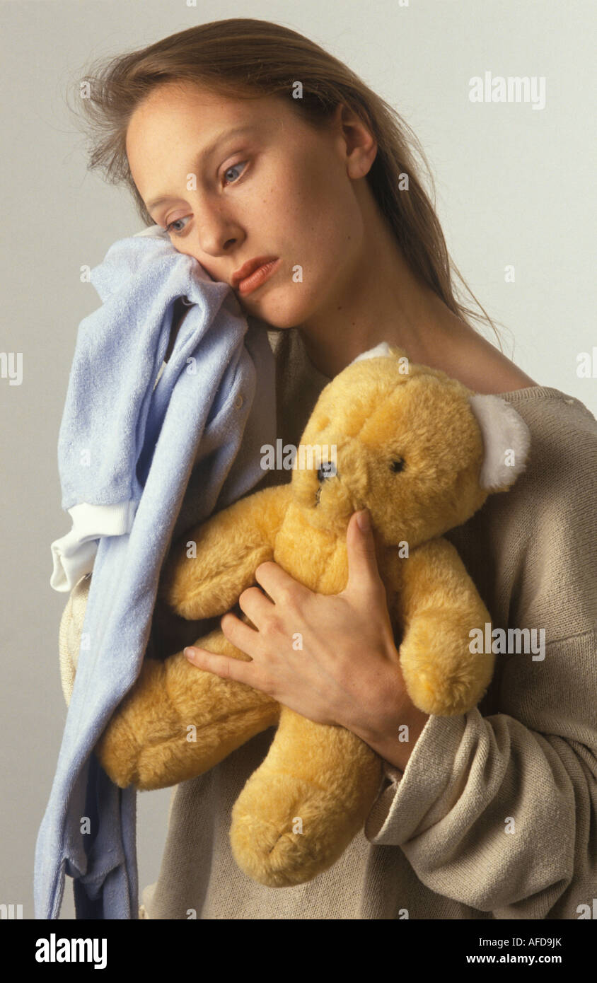 Donna con bambino gro e orsacchiotto cercando triste Foto Stock