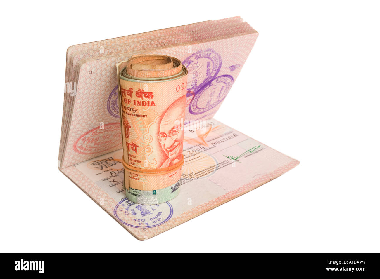 Rotolo di rupie indiane su un passaporto britannico con un Indiano Visa. Isolato su bianco. Foto Stock