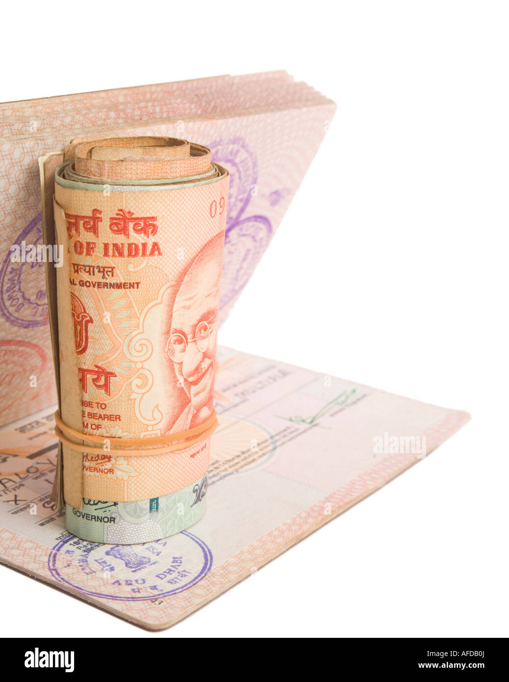 Rotolo di rupie indiane su un passaporto britannico con un Indiano Visa. Isolato su bianco. Foto Stock