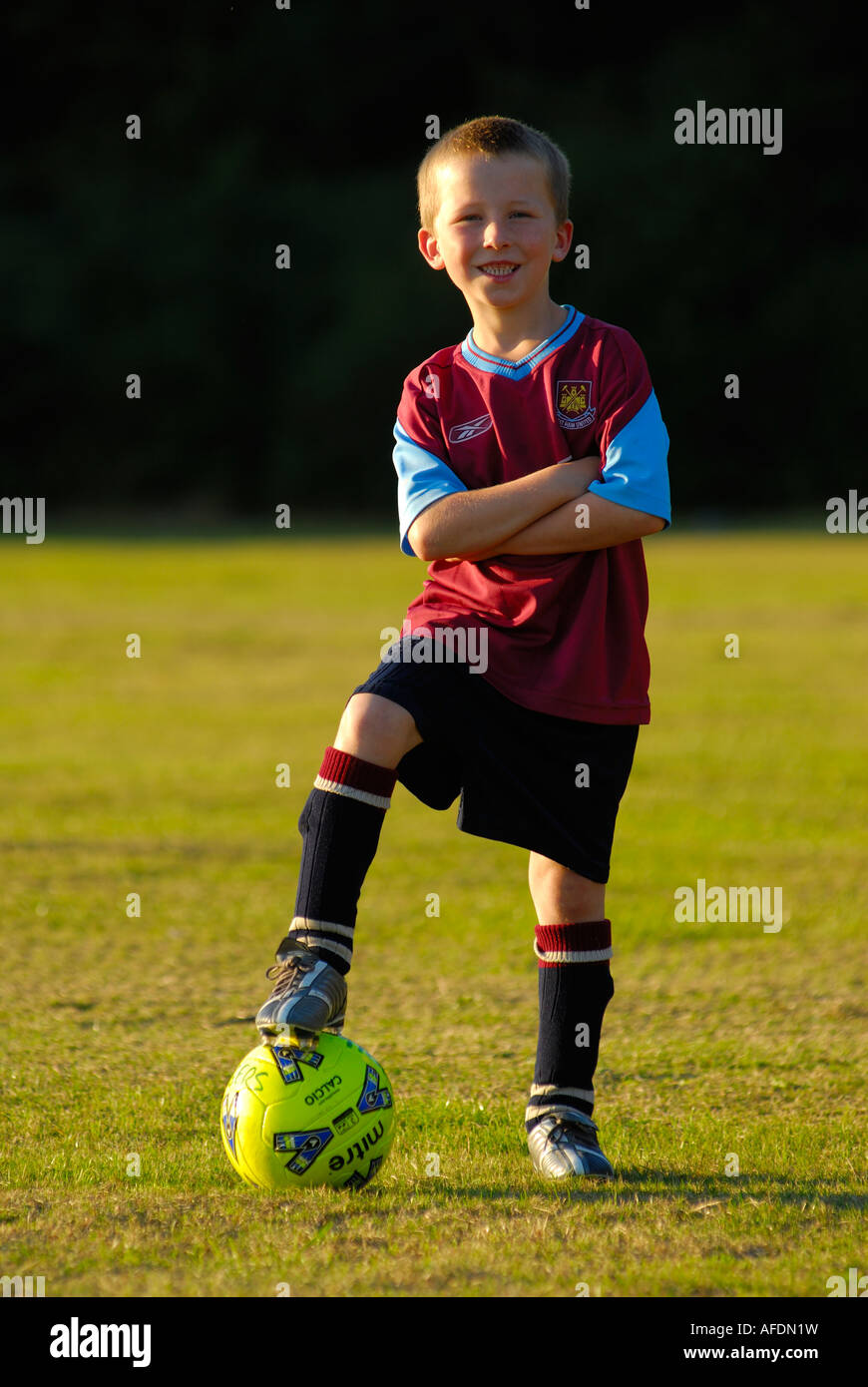 Giovane ragazzo in piedi con il calcio. Foto Stock