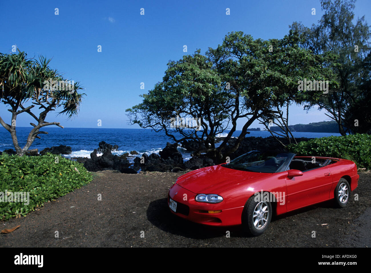 Rosso convertibili sul litorale, Strada di Hana, vicino Keanae, Maui, Hawaii, STATI UNITI D'AMERICA Foto Stock
