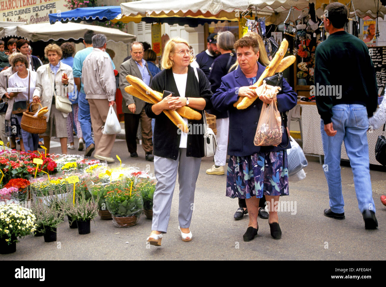 Le donne francesi a comprare il pane in un mercato all'aperto in uno dei quartieri di Parigi, Parigi, Francia. Foto Stock