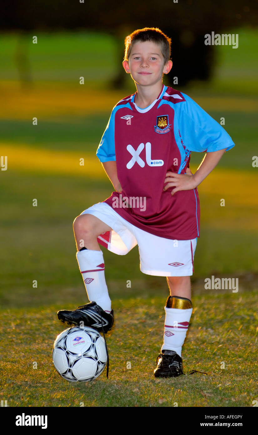 Giovane ragazzo in piedi con il calcio. Foto Stock