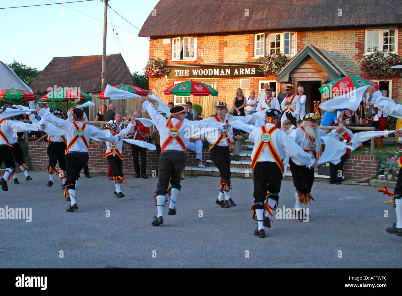 Morris ballerini eseguono balli tradizionali su una serata estati al di fuori di una Sussex public house. Foto Stock