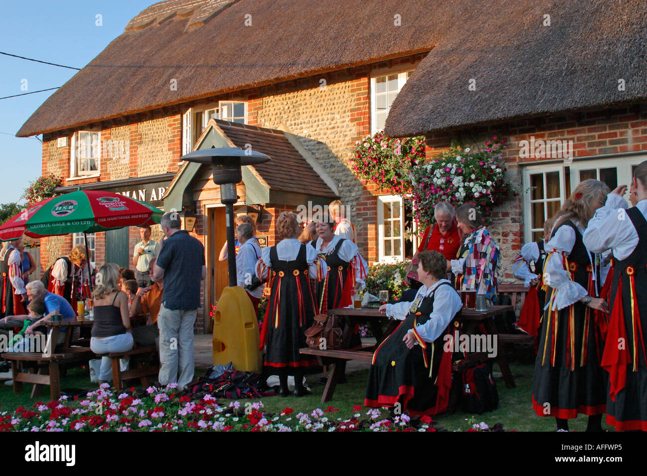 Un gruppo di lady Morris ballerini rilassante tra prestazioni al di fuori del Sussex pub. Foto Stock