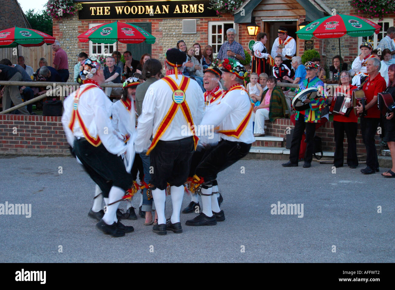 Morris ballerini eseguono balli tradizionali su una serata estati al di fuori di una Sussex public house. Foto Stock