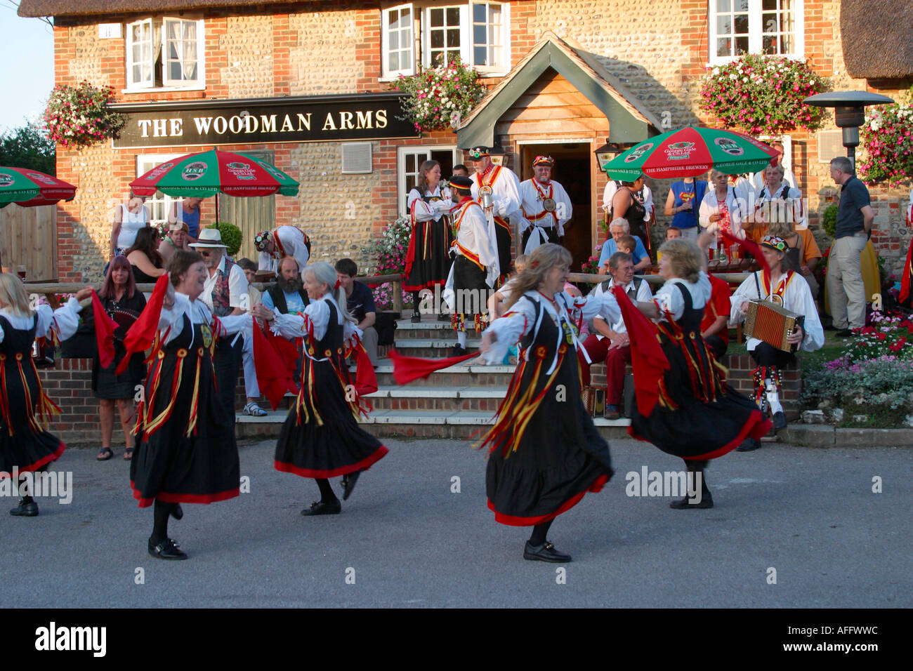 Signora Morris ballerini eseguono balli tradizionali su una serata estati al di fuori di un locale pubblico nel Sussex Foto Stock