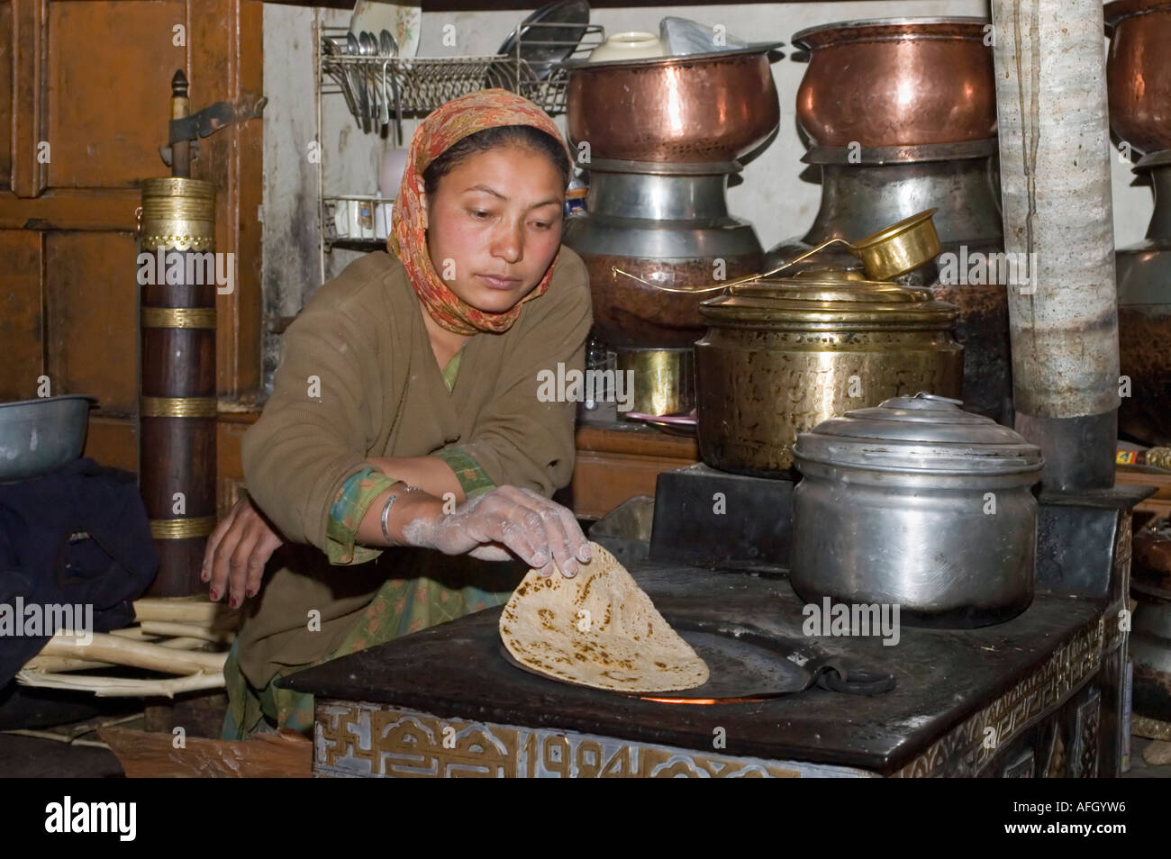 Donna chapatis cottura in cucina, Nurla, Indus Valle, Ladakh, Jammu e Kashmir India Foto Stock