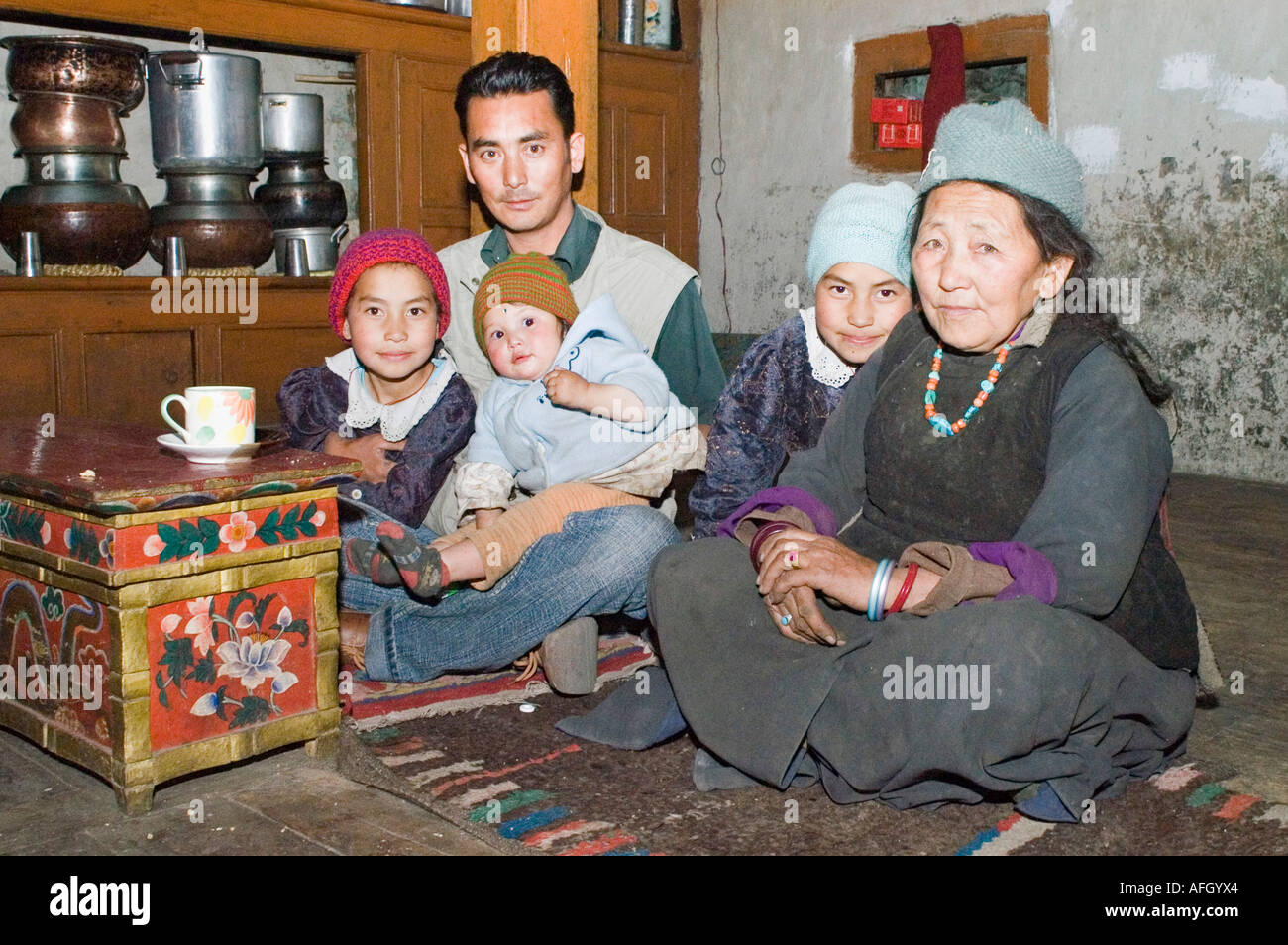 Famiglia di Ladakh seduta in cucina, Nurla village, Indus Valle, Jammu e Kashmir India Foto Stock