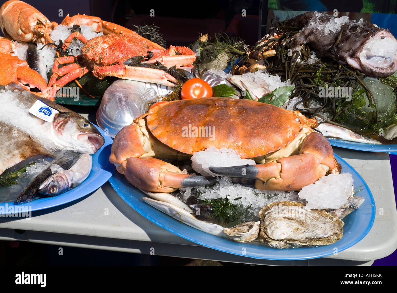 dh SEAFOOD JERSEY grande granchio intero su piatto Jersey prodotti in vendita frutti di mare cibo crudo vassoio pesce fresco canale isole mercato Foto Stock