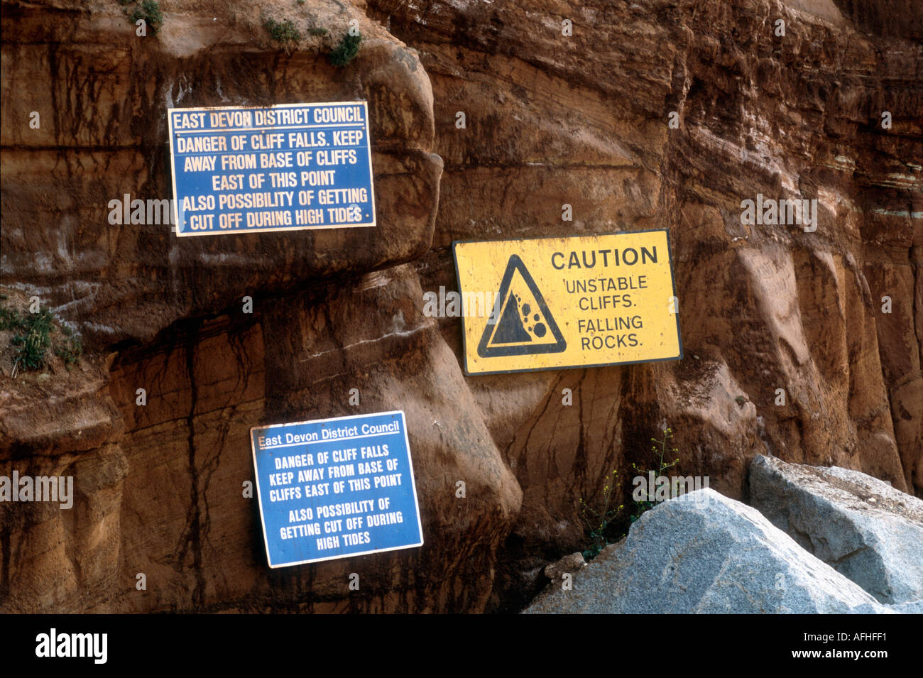 Caduta di massi e alta marea pericolo avvisi a Sidmouth in Devon England Regno Unito Foto Stock
