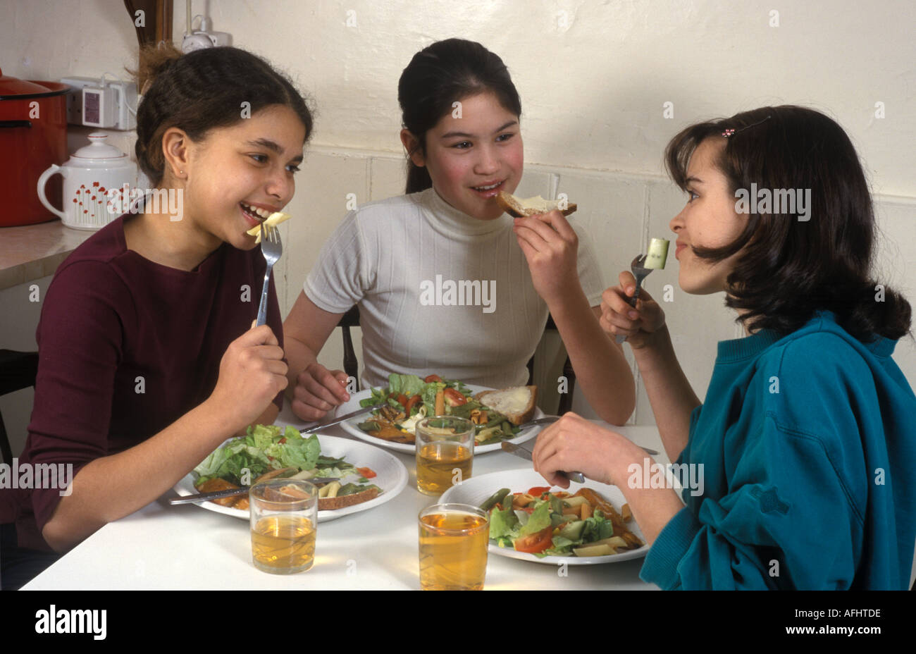 3 giovani ragazze adolescenti di mangiare cibo sano Foto Stock