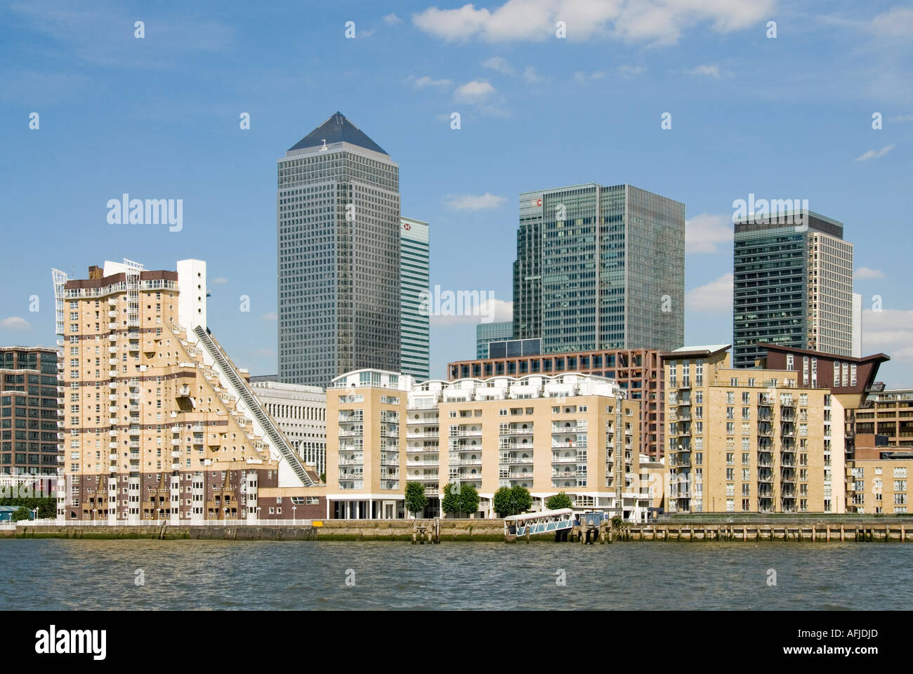 River Thames River side condomini vicino al Docklands Canary Wharf complesso di uffici di ristrutturazione visto oltre East London Inghilterra Regno Unito Foto Stock