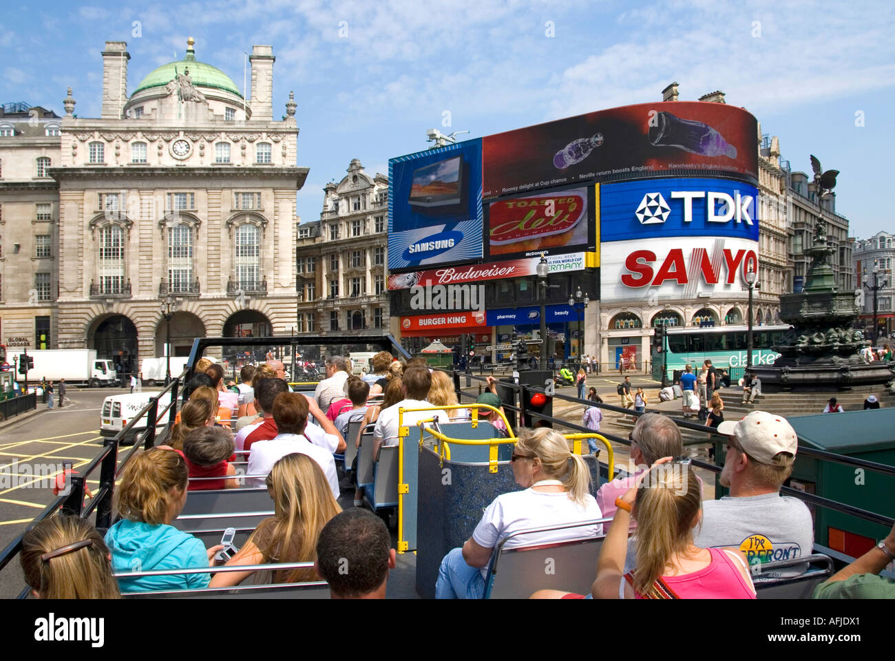 Londra passeggeri a bordo ponte superiore di open top sightseeing tour bus con turisti viste verso Piccadilly Circus & Eros con un cartellone pubblicitario REGNO UNITO Foto Stock