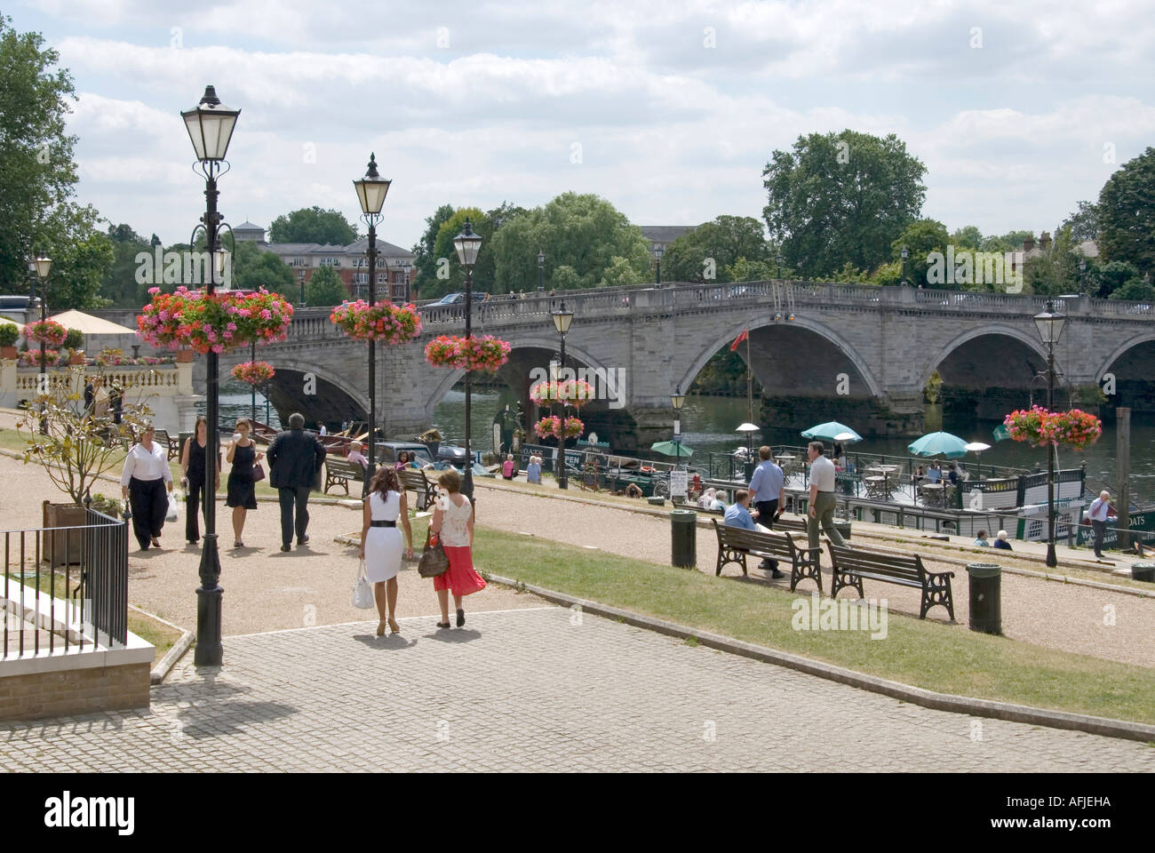 Storico Richmond Upon Thames River Bridge e le persone camminano soleggiate passeggiata sul lungofiume accanto al terrapieno con cesto sospeso Londra Inghilterra REGNO UNITO Foto Stock