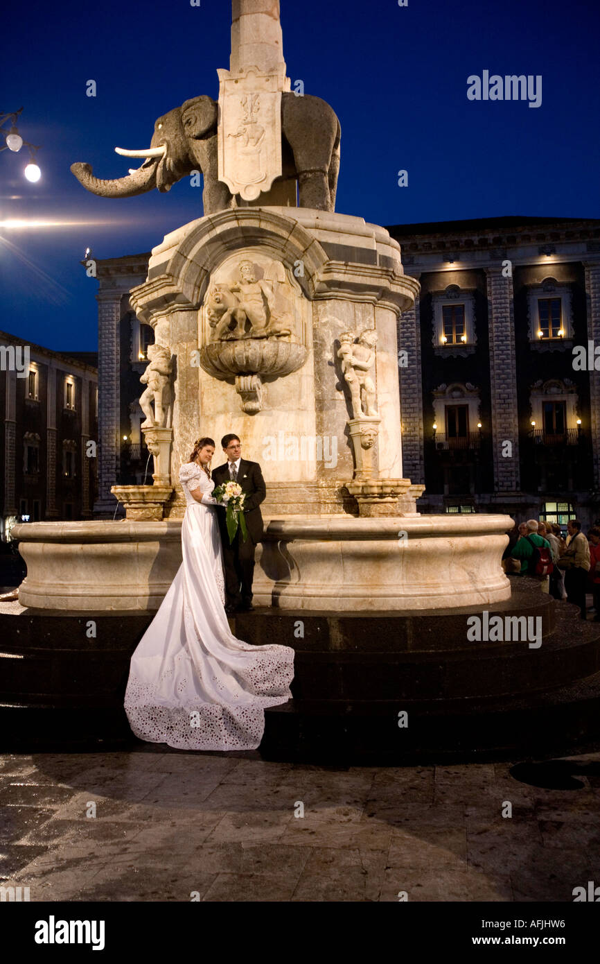 Coppia appena sposata che pongono sotto l'elefante di Piazza Duomo di Catania per un'immagine Sicilia Italia Foto Stock