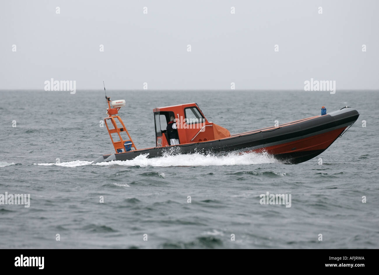 Orange costola rigida mondati barca gonfiabile RHIB su prove in mare a velocità in grigio il mare e il cielo off Ballycastle Irlanda del Nord Foto Stock