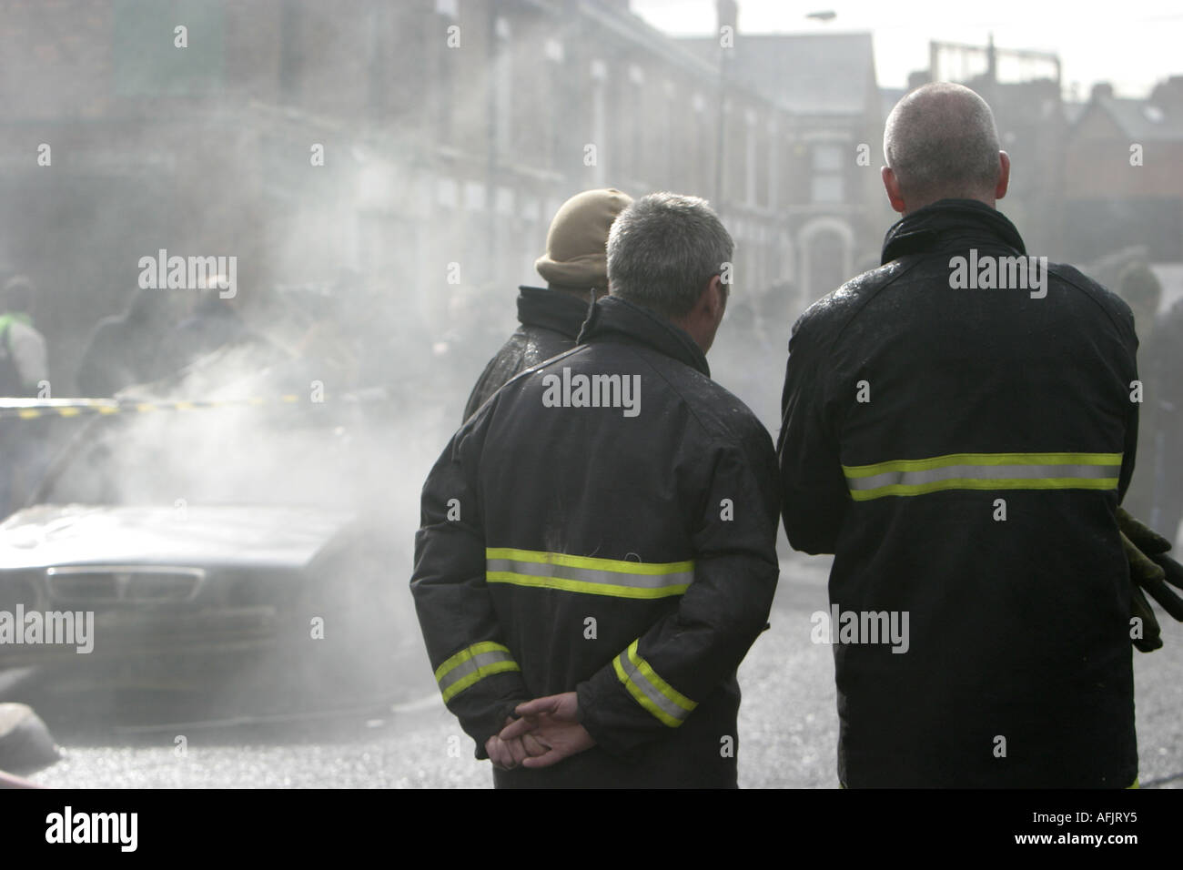 I vigili del fuoco guarda la masterizzazione di auto le riprese sul set del film di chiudere l'anello in base a Belfast negli anni settanta anni ottanta girato nel 2006 Foto Stock