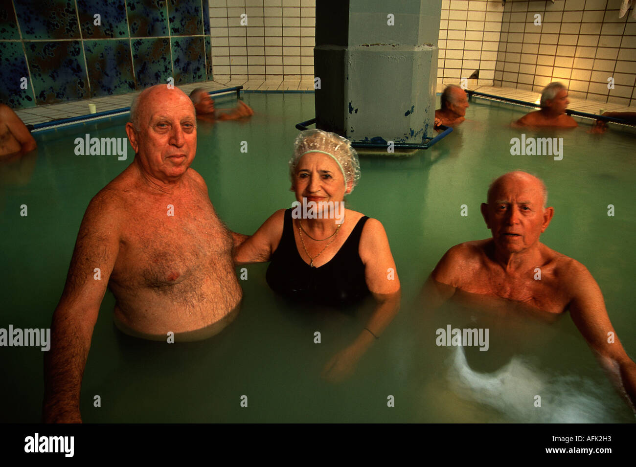 Gli anziani in vacanza bagna in una piscina termale medicinale piena di acqua salata del Mar Morto a Ein Gedi Spa Israele Foto Stock