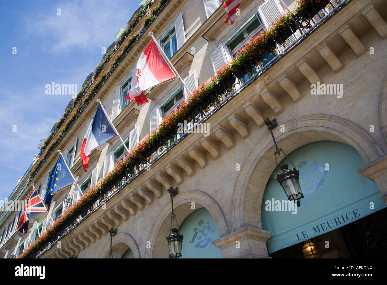 Francia Ile de France Parigi Rue de Rivoli Hotel a cinque stelle Le Meurice con bandiere e rosso dei gerani in scatole di finestra sul balcone Foto Stock