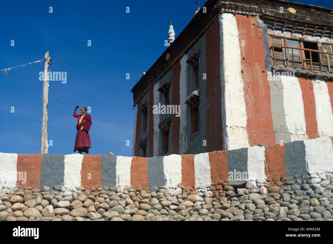 Il Nepal Sud Asia Himalaya Mustang rosso e pareti bianche di Tsarang monastero Buddista Tibetana monaco guardando dalla terrazza del monastero Foto Stock