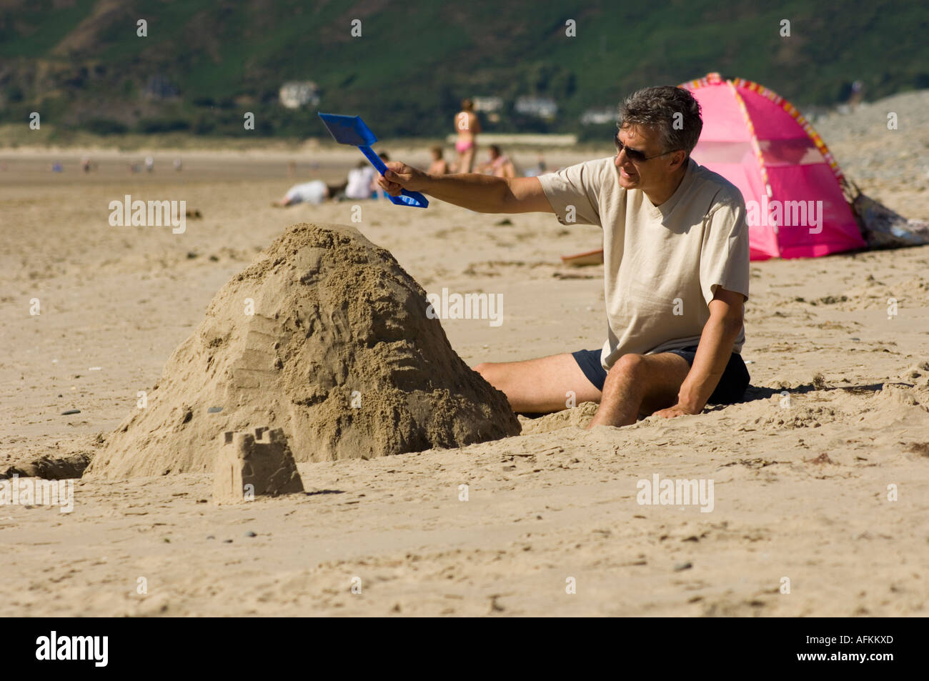 L'uomo costruire castelli di sabbia con una plastica blu forcella sul Ynyslas beach e sabbie, Borth Ceredigion nel Galles Foto Stock
