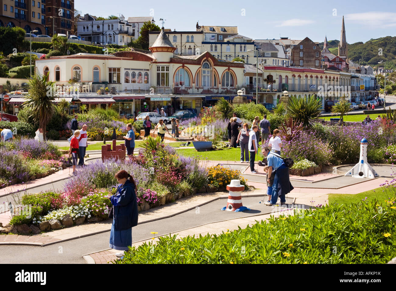 Turisti e villeggianti che giocare a minigolf o minigolf presso la cittadina di mare sulla passeggiata a Ilfracombe, Devon, Regno Unito Foto Stock
