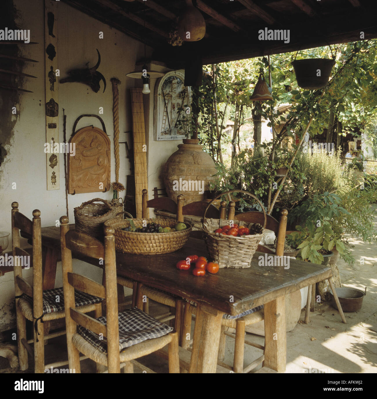 Tavola in legno rustico e la scaletta sedie a schienale sulla veranda del piccolo cottage italiano Foto Stock