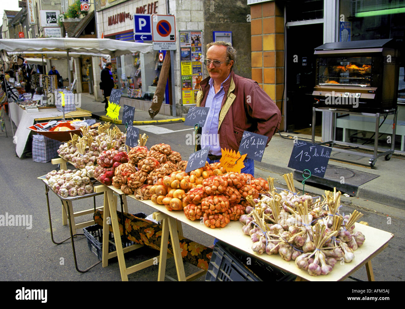Un fornitore vende frutta e verdura presso un mercato all'aperto in uno dei quartieri di Parigi Foto Stock