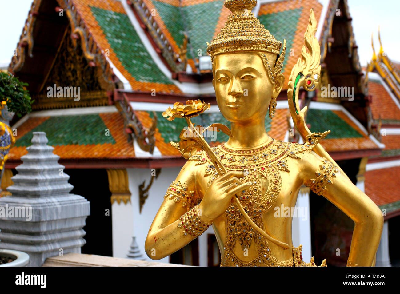 Mitico golden dorare la metà femmina umana demon tenendo un bocciolo di loto al più grande wat Buddhisti in Thailandia il Grand Palac Foto Stock