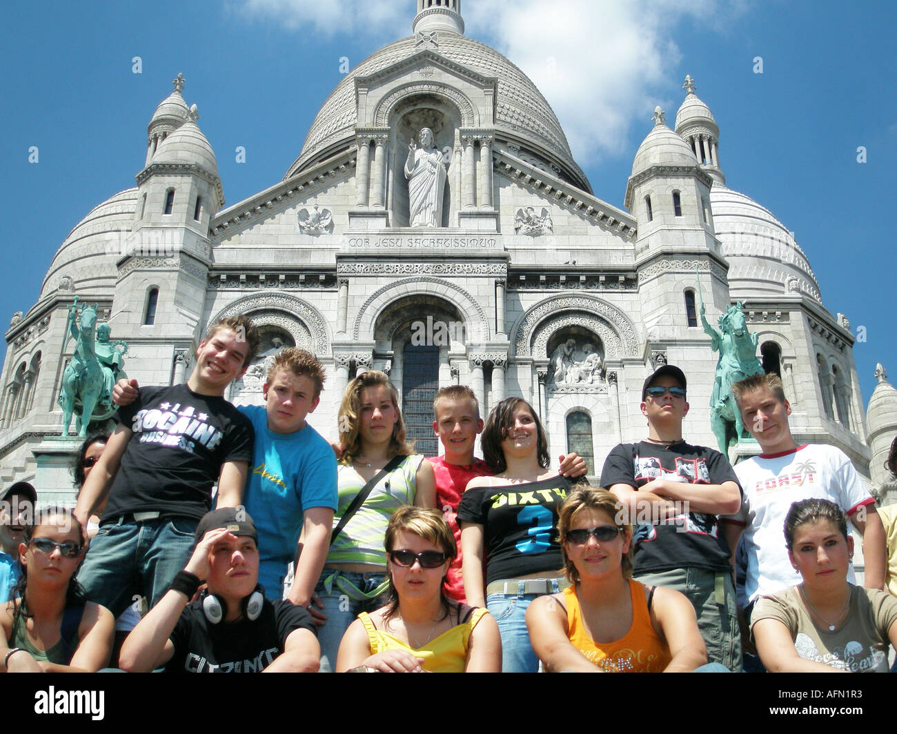 Gruppo di studenti adolescenti seduti sui gradini nella parte anteriore del Sacre Coeur di Montmartre Parigi Francia Foto Stock