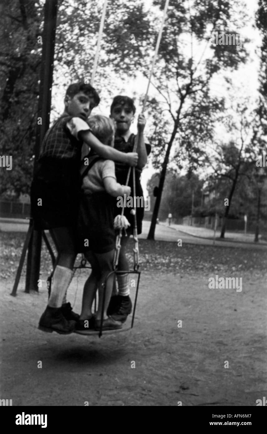Persone, bambini, giocare, tre bambini in un'altalena, Germania, 1948, parco giochi, periodo del dopoguerra, , Foto Stock