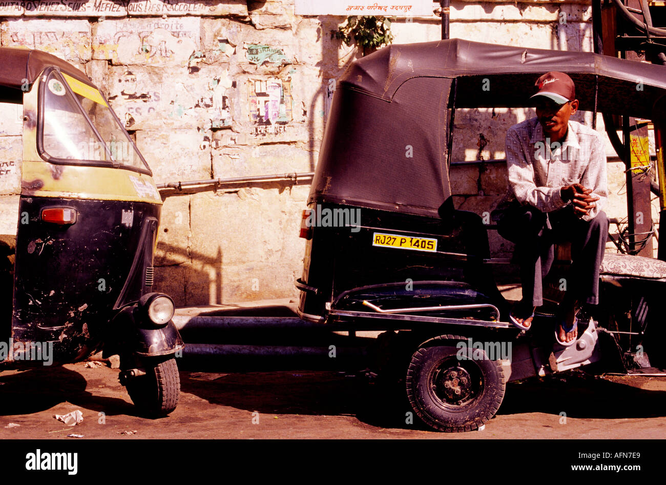 Uno maschile seduto in un auto rickshaw sulla strada in attesa di passeggeri all'aperto durante il giorno Udaipur India Asia Foto Stock